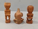 three wooden figurines sitting next to each other on a table