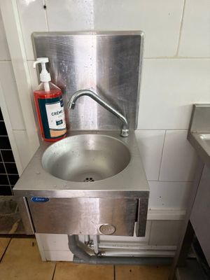 un évier équipé d'un robinet et d'un distributeur de savon, situé dans un coin de la cuisine