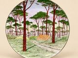 une assiette sur laquelle est représentée une scène de forêt