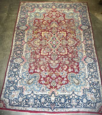 a red and blue rug with a floral design on it