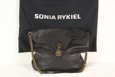 un sac à main noir auquel est suspendue une chaîne dorée
