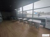 de nombreuses tables et chaises dans une pièce dotée d'une grande fenêtre