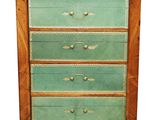 an old wooden chest of drawers with a green glass top