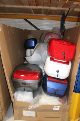 de nombreuses valises rangées dans un carton posé sur une étagère