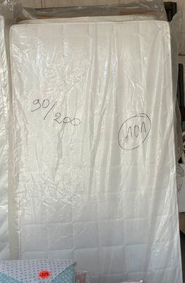un tas de matelas et d'autres objets dans un entrepôt