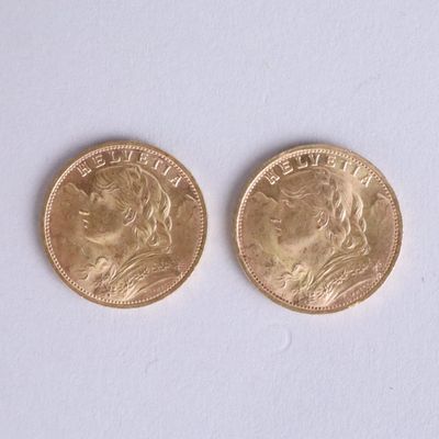two gold coins sitting side by side on a white surface