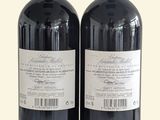 two bottles of red wine sitting next to each other on a table