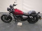 a picture of a red motorcycle parked on a checkered floor