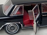 a black car with its door open and a red seat in the back