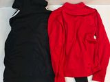 pair of red and black sweatshirts sitting on top of a white table