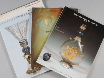 trois livres posés sur une table, avec un vase en verre et un livre
