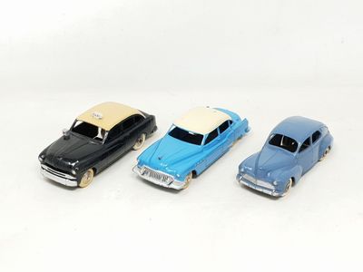 three toy cars sitting next to each other on a white surface