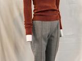 an image of a mannequin wearing a brown sweater and grey pants