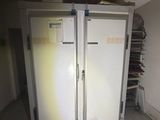 two white refrigerators in a room with a white tiled floor