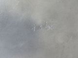 silver plate with writing on the side of it on a table
