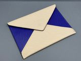 Deux enveloppes à rayures bleues et blanches sont posées sur une surface grise.