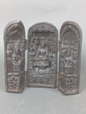 une petite statue représentant un homme et une femme devant une porte