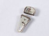 two pieces of silver and mother of pearl on a white surface