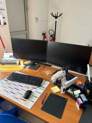 un bureau sur lequel sont posés deux écrans d'ordinateur et un clavier