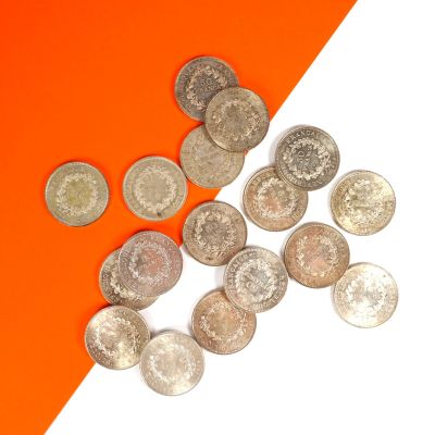 quelques pièces d'argent sont dispersées sur un fond orange et blanc