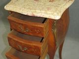 a small wooden table with three drawers and a marble top