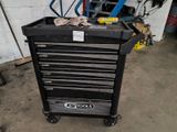 a black tool box with tools on it in a garage