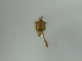a small clock hanging from a chain on the wall
