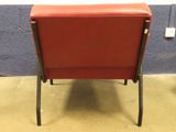 a red chair that is sitting in front of a blue wall