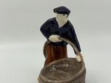 an image of a figurine of a man sitting on top of a wooden stump