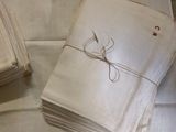 une pile de serviettes blanches posée sur une table, à côté d'une paire de ciseaux
