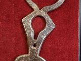 a metal key that is shaped like a heart on a red cloth