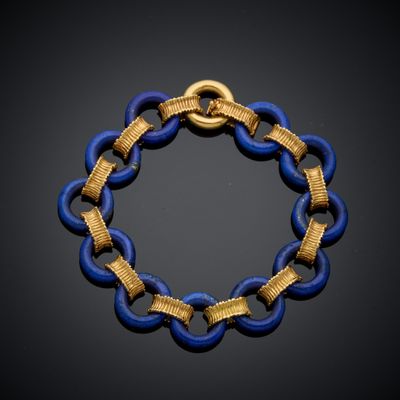 un gros plan d'un bracelet bleu et doré posé sur une surface noire