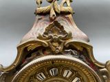 a close up of a clock with a bird on top of it