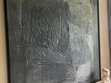 a painting on the wall next to a table with a lamp