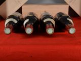 bottles of wine are lined up on a red table cloth