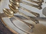 a lot of spoons that are sitting on a silver plate