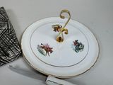 a white plate with a gold handle and a black and white cloth