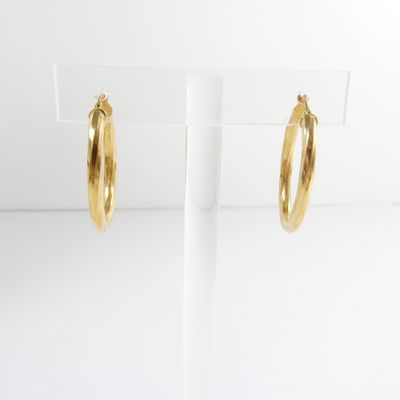 a pair of gold hoop earrings on a white stand