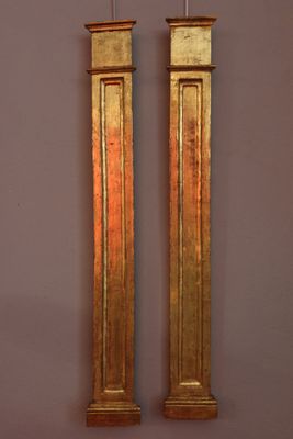 pair of antique brass clock faces on a pink wall