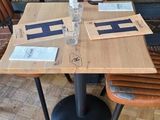 tables and chairs in a restaurant with wooden flooring and red chairs