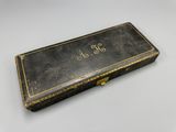an old black box with gold writing on it sitting on a table