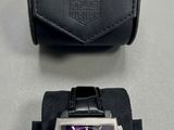 montre et boîtier violets et noirs sur un fond blanc