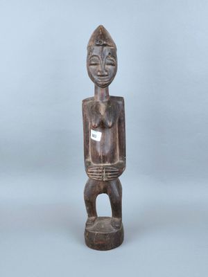 une statue en bois d'un homme avec un chapeau sur la tête