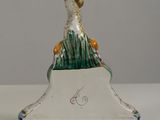 porcelain figurine of a duck sitting on top of a green and white base