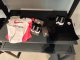a table with a pair of sneakers, a t - shirt, and a pair of shoes on it