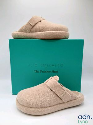 des chaussons en laine dans une boîte, sur fond blanc, avec une boîte verte