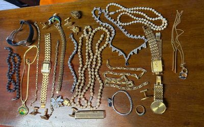 a wooden table with a bunch of jewelry on it