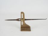 a small wooden object with a knife on top of it