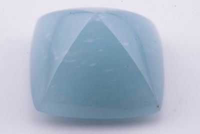 un gros plan d'un objet en verre bleu posé sur une surface blanche