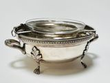 a silver bowl with a lid on a white surface